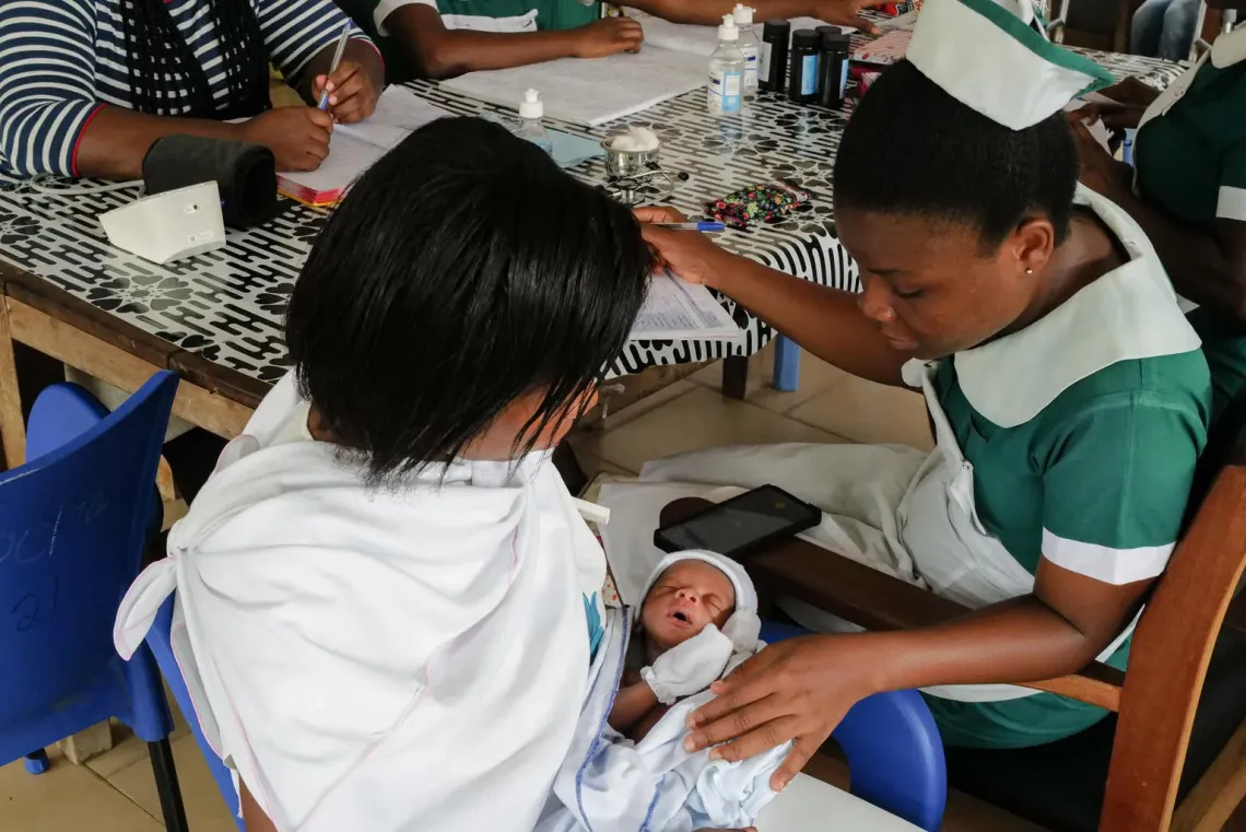 A nurse attends to a mother and her baby.