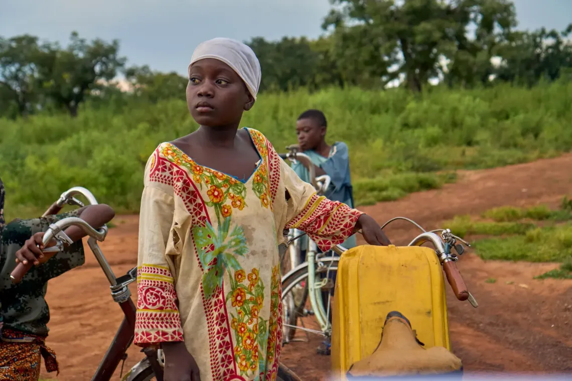 In Gbetabu, a small community in Yendi, Rahmah, daughter of Salamatu, stands beside her bicycle after finishing the task of drawing water. 