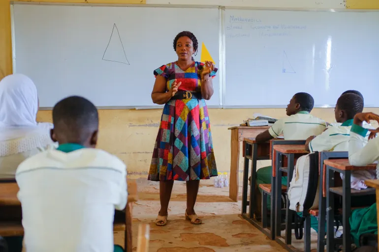 A teacher  and students during a class interaction 