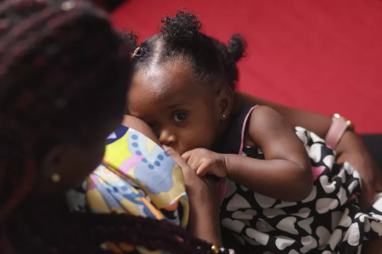 A mother breastfeeds the child.