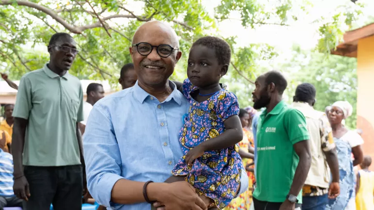 A picture of UNICEF Representative with a child from the community 