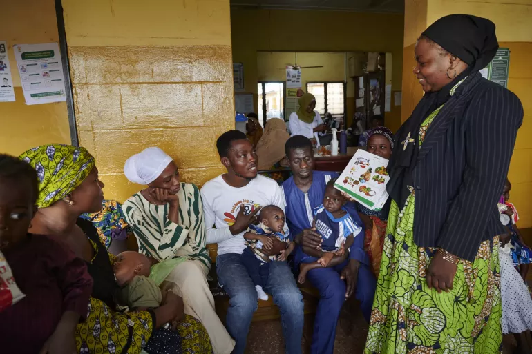During a health education session, Yussif holds his malnourished child Hidir 