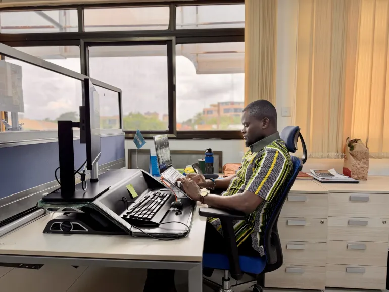 A picture of Kenneth sitting behind his desk during a regular workday.