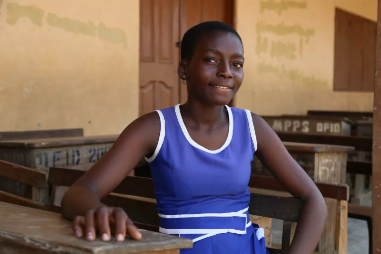 Beatrice, a student of Presby Primary-Mepe, happy to receive learning materials.