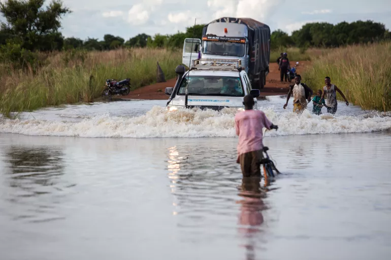 car driving through flooded road boy in front of car