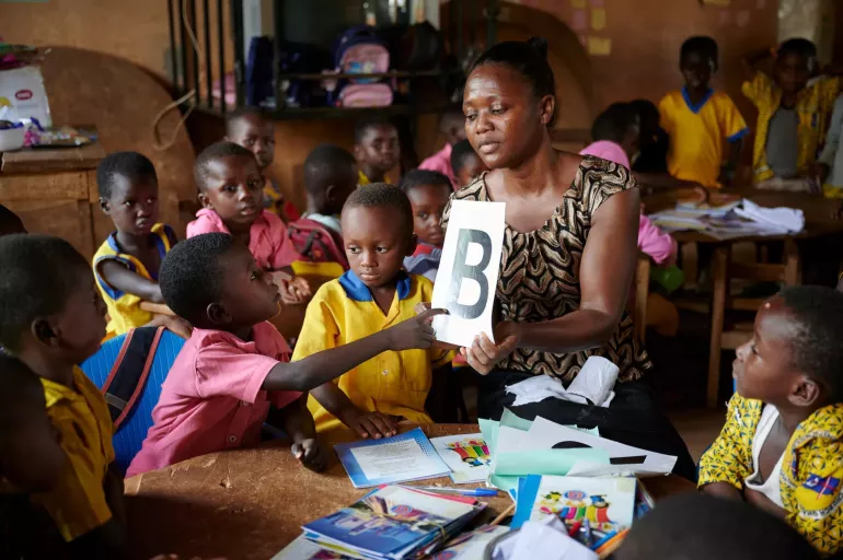 Ms. Ana Lydia assist children in a kindergarten classroom at Atia Methodist Primary school in Juaben Municipality in Ashanti Region of Ghana.