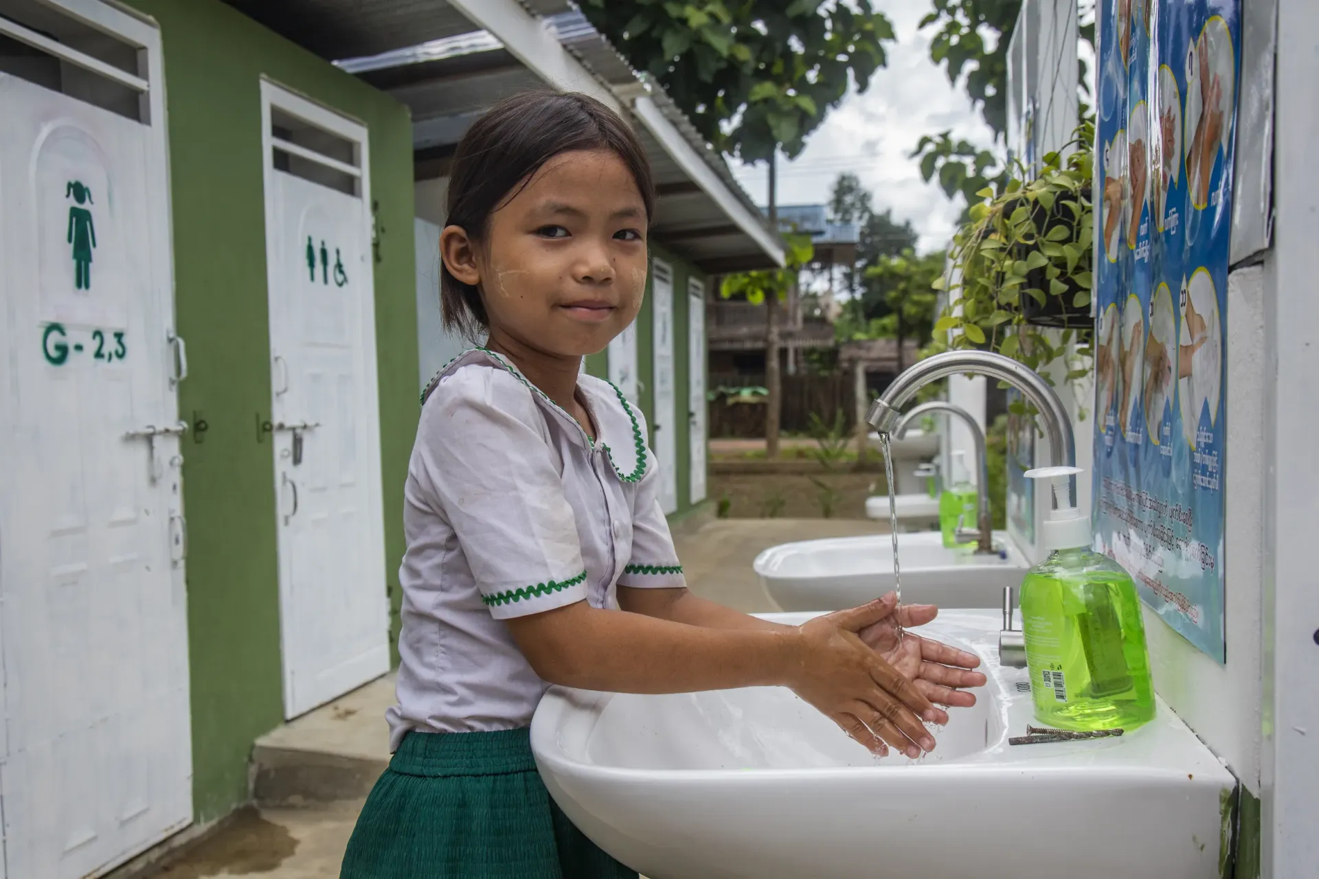 A child washes her hands outside the toilet after use at a school supported through Korea&rsquo;s partnership with UNICEF 