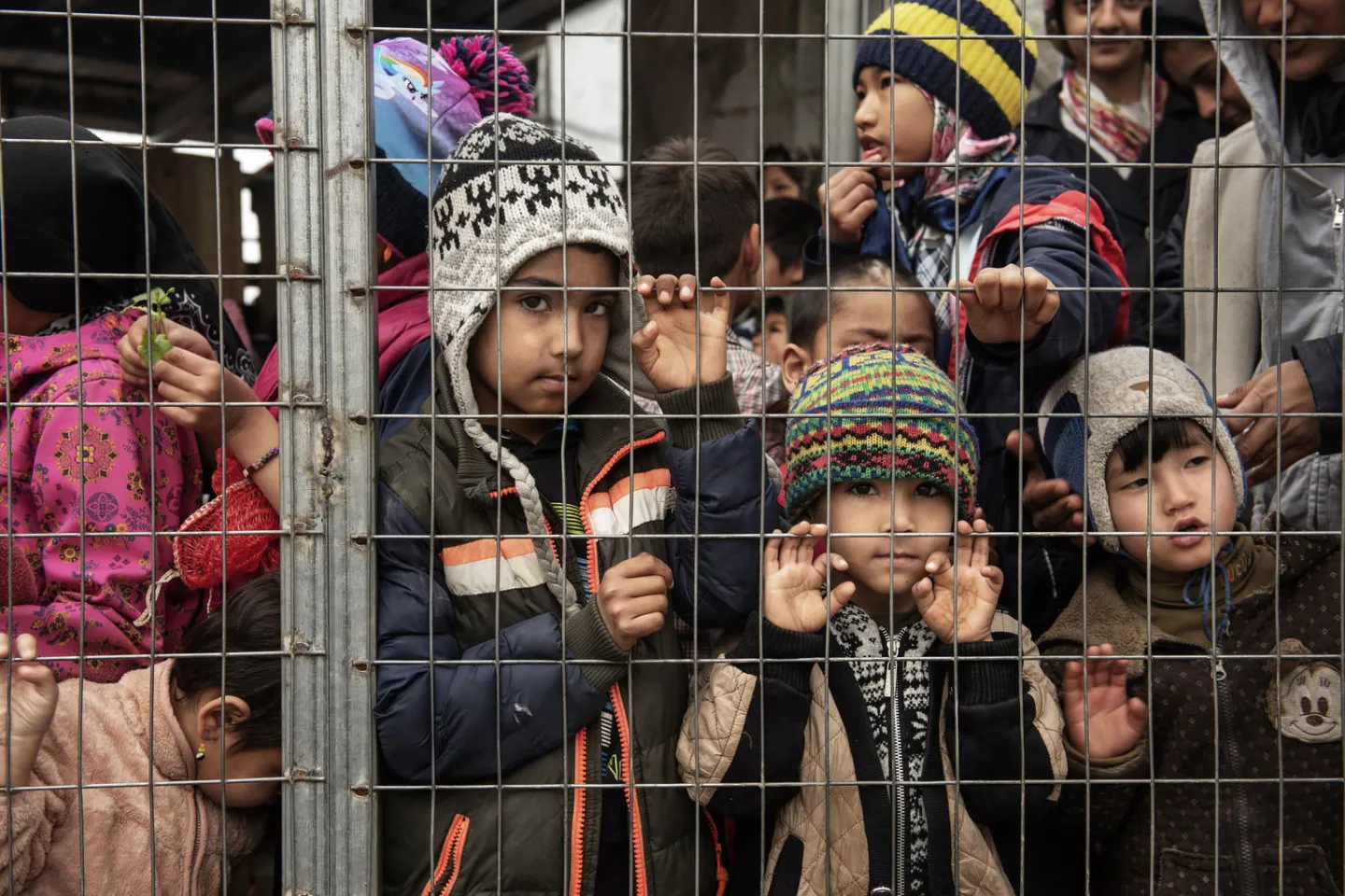 On 8 March 2020, children line up for fruit juice behind a barbwire fence in the Reception and Identification Centre in Moria, on the island of Lesvos, in Greece.