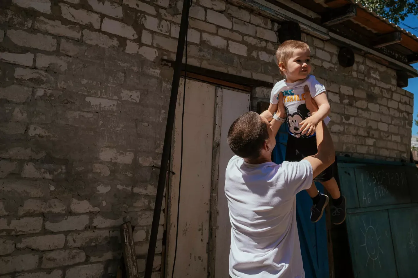 Yevhen is holding his three-year-old son in his hands. 