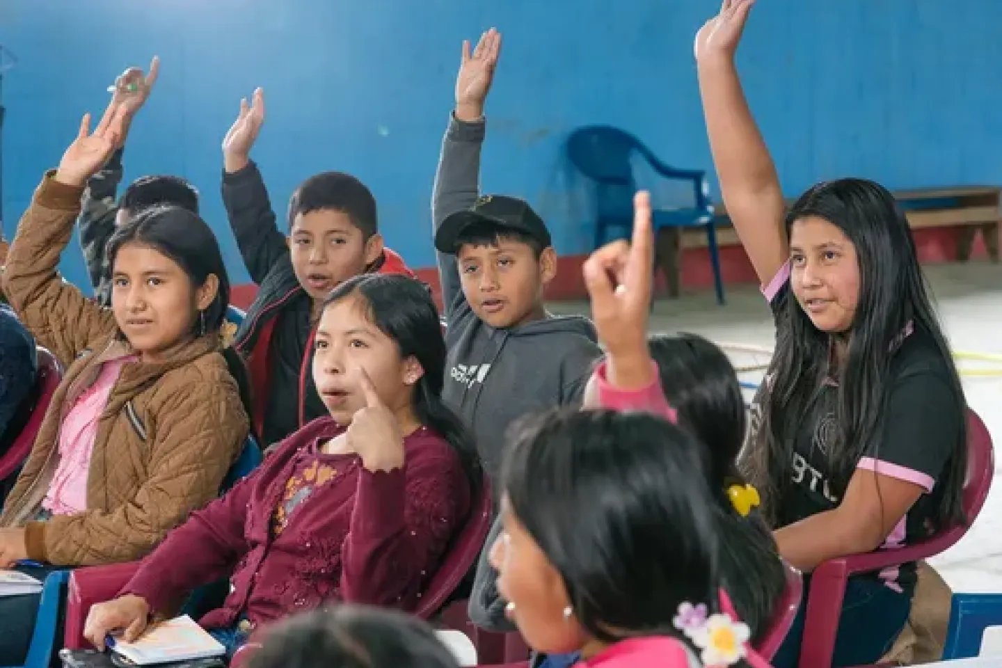 ni&ntilde;as y ni&ntilde;os levantando la mano 