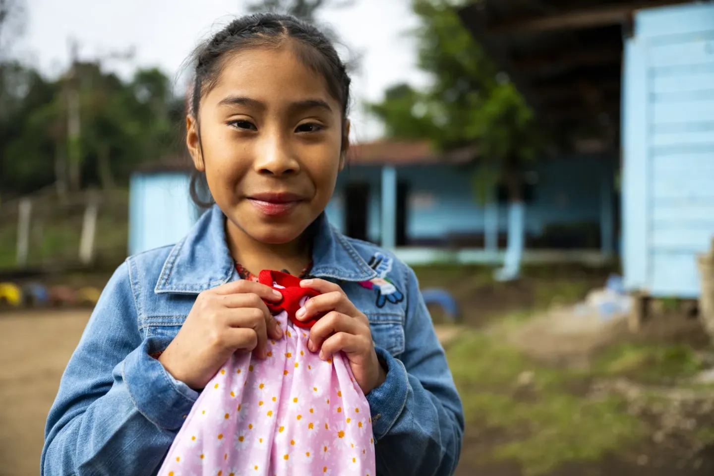 Ni&ntilde;a con bolsa rosada en manos