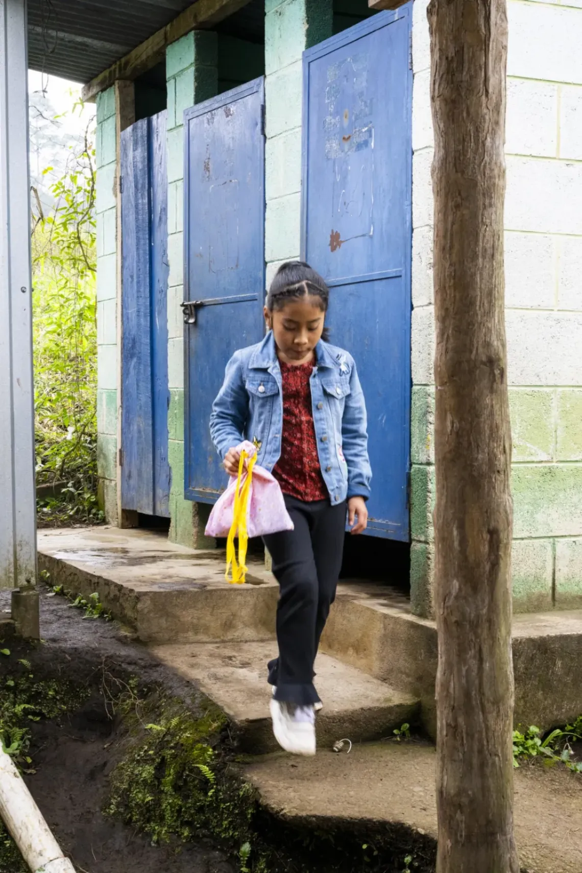 Ni&ntilde;a caminando con bolsa de art&iacute;culos de higiene n manos