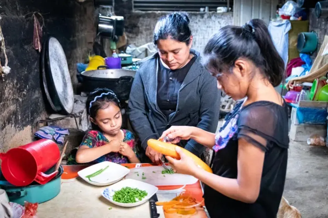 madre y dos hijas preparando los alimentos