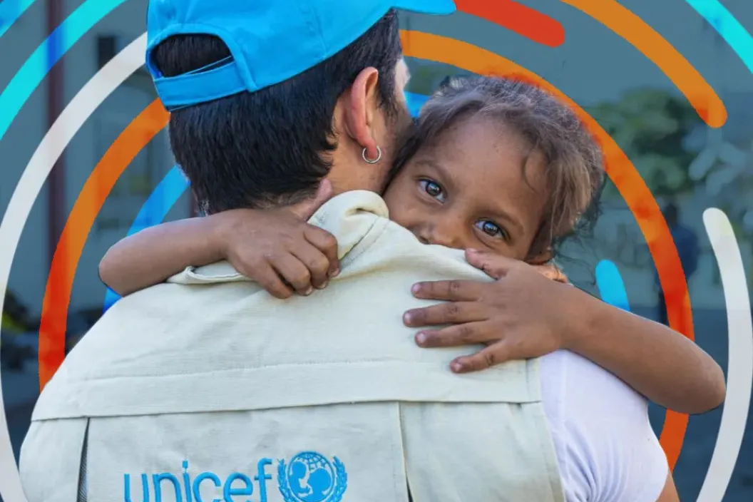 personal de UNCIEF abraza a una ni&ntilde;a en contexto migratorio