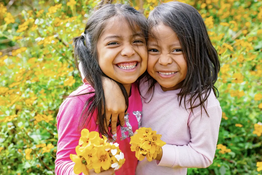 Foto footer dos ni&ntilde;as en campo de flores amarillas