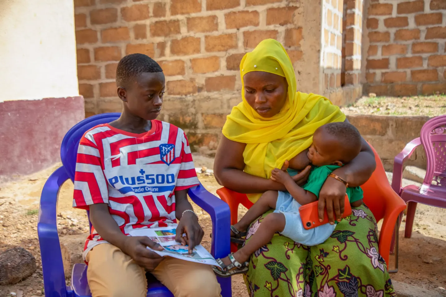 Hassan explique &agrave; sa grande-s&oelig;ur, les avantages de la vaccination pour son enfant, Beyla, Guin&eacute;e.