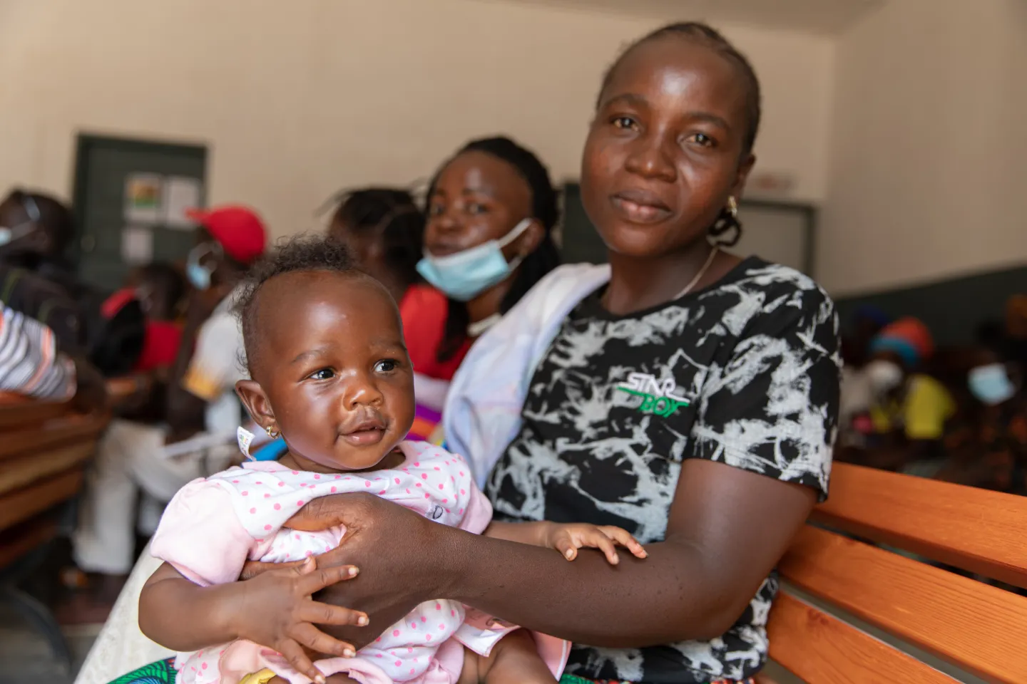 The little Seny Koly, laughing on the knees of her mother, Mamy Haba, health center of the commune of convergence of Kobéla, region of Nzérékoré in Guinea.
