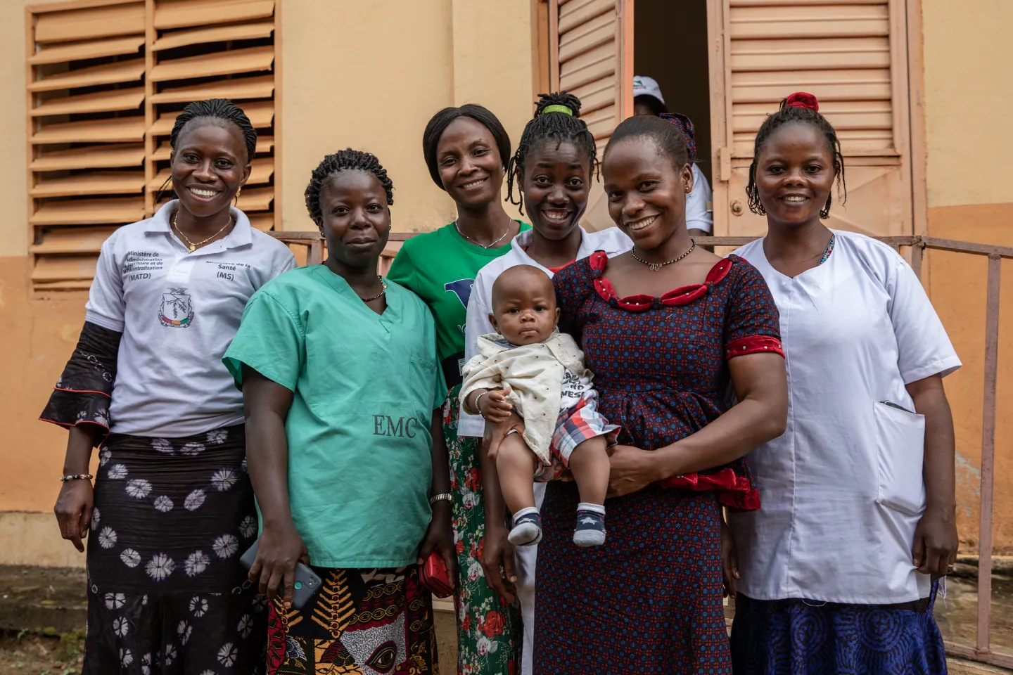 The team of caregivers poses with the son of a nurse aide, Traoré 6 months, Bossou health center, Bossou rural township in the Nzérékoré region of Guinea.