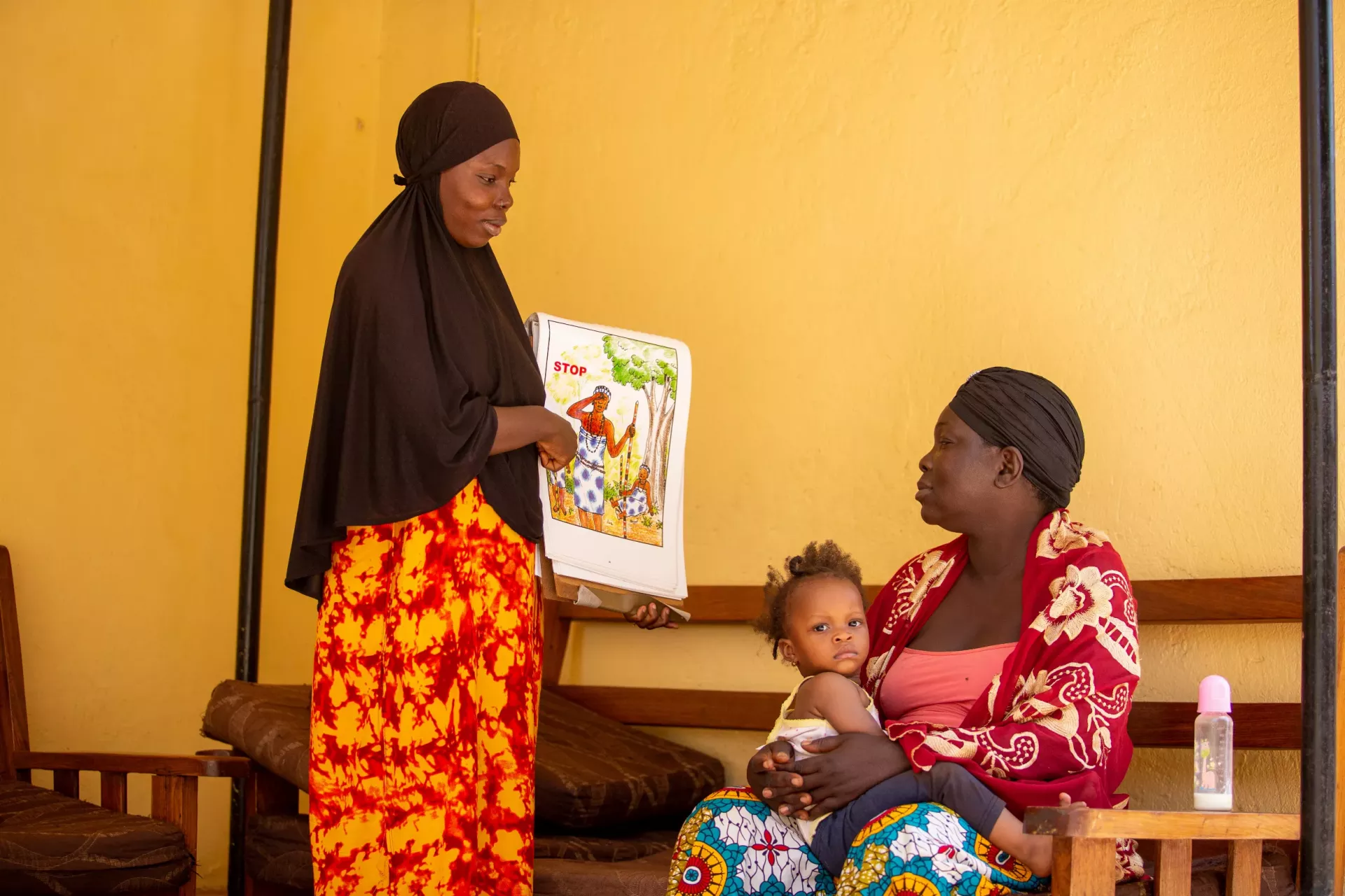 Aissatou Keita, president of the Young Women Leaders Club of Sangar&eacute;di, raises awareness with Kadiatou Diallo, holding her 1-year-old daughter Bountouraby, about the harmful practices of FGM. 