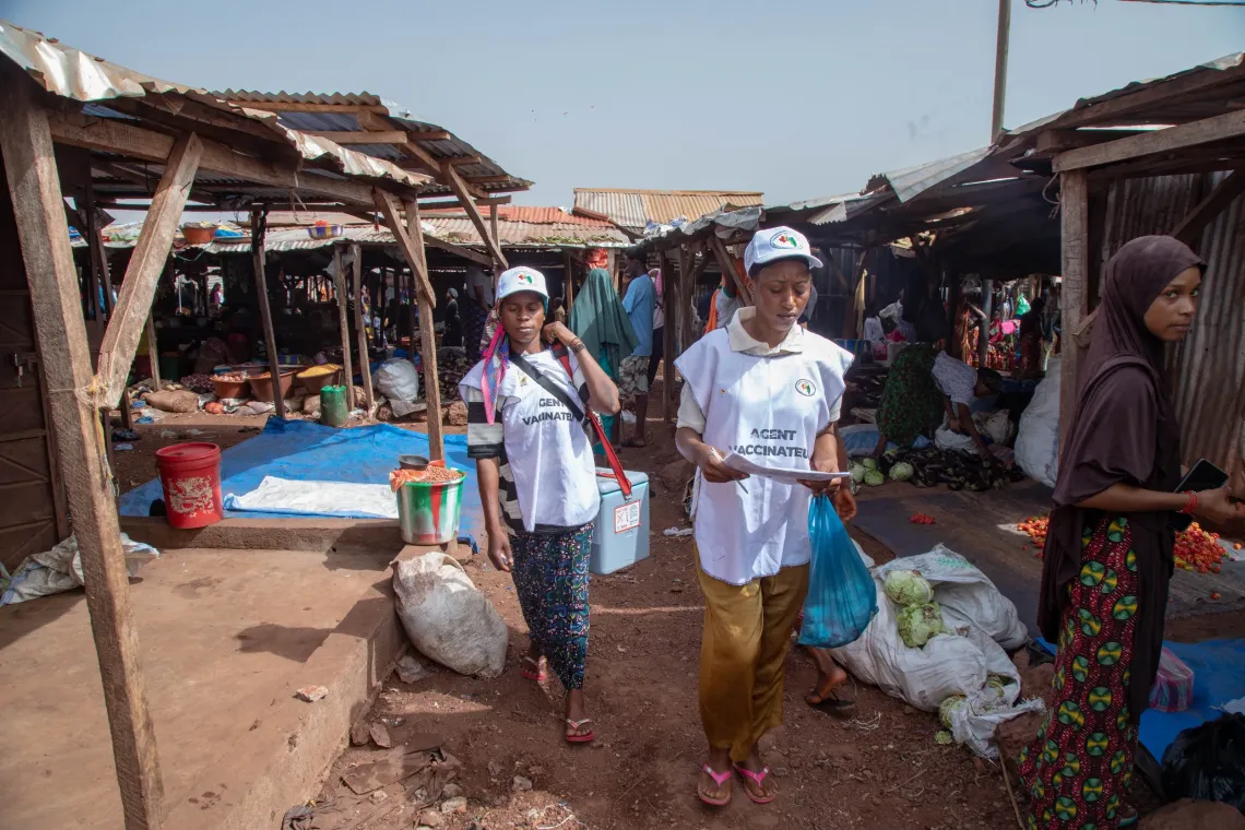 Un agent vaccinateur sillonne le march&eacute; pour vacciner les enfants.