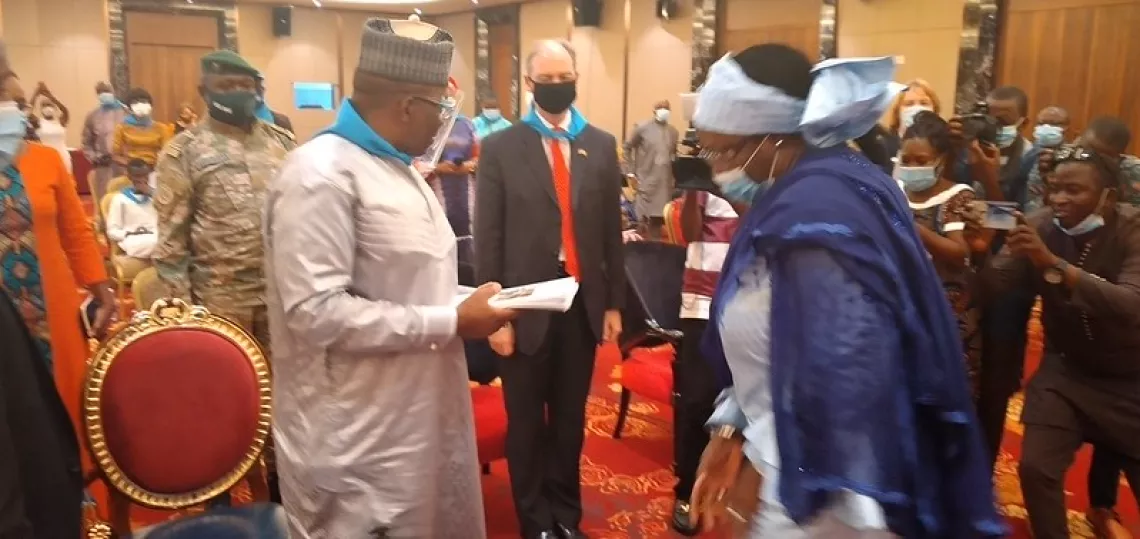 Dr Ibrahima Kassory Fofana, Premier Ministre Chef du Gouvernement recevant des mains de Hadja Mariama Sylla, Ministre de l&rsquo;Action Sociale et des Personnes Vuln&eacute;rables, le plan strat&eacute;gique national de Promotion de l&rsquo;Abandon du Mariage d&rsquo;Enfant en Guin&eacute;e