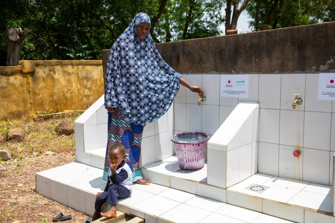 Issatou et son fils Thierno, 2 ans 10 mois, &agrave; la borne fontaine du centre de sant&eacute; de Bantignel, Guin&eacute;e.