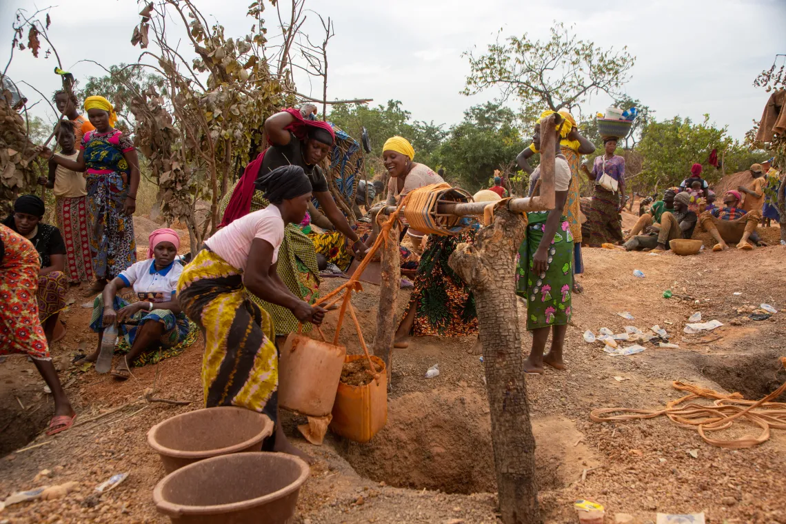 Accompagn&eacute;es par leurs enfants, des femmes recherchent de l'or dans la zone mini&egrave;re de Doko, Siguiri, Guin&eacute;e.