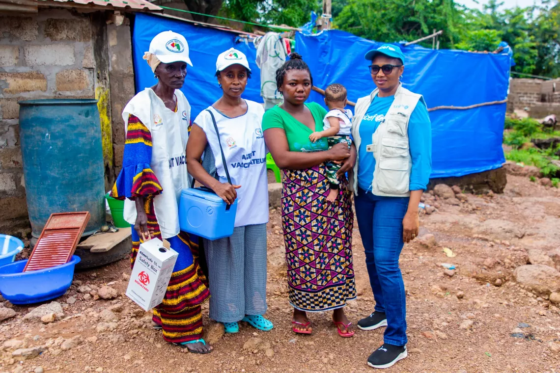 Mata Kourouma and her 6-month-old Son Ibrahima surrounded by the health team during the vitamin A registration and vaccination campaign on the island of Kassa, Guinea.