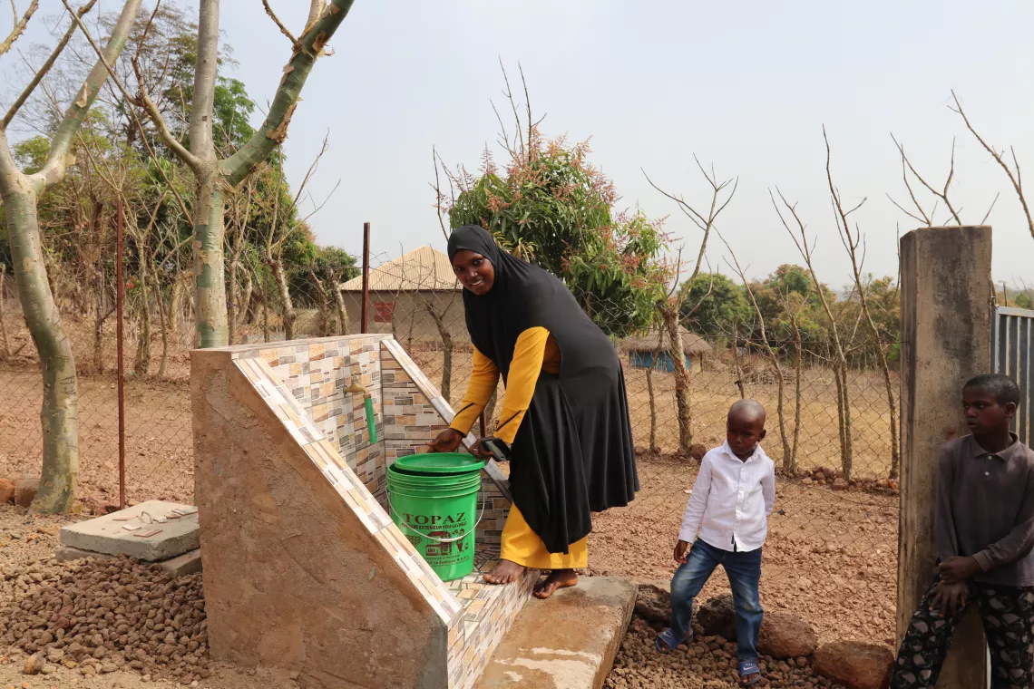 Fatoumata Diariou Diallo, mamans de 4 enfants, remplit son seau &agrave; la borne fontaine 