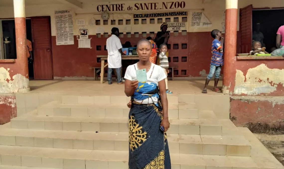 Mawa montre son carnet de vaccination apr&egrave;s avoir re&ccedil;u sa premi&egrave;re dose de vaccin contre la  COVID-19, N'Zoo, Guin&eacute;e.