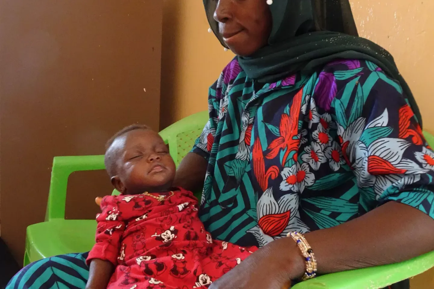 Diara Cassama and her 14-month-old daughter, Suncar, sit outside the nutrition recuperation ward. 