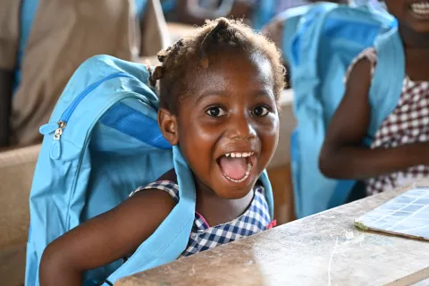 A girl smiles beautifully and energetically at school.