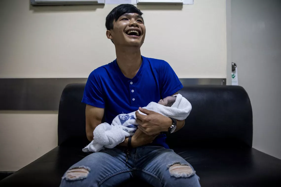 Happy dad holds his newborn baby