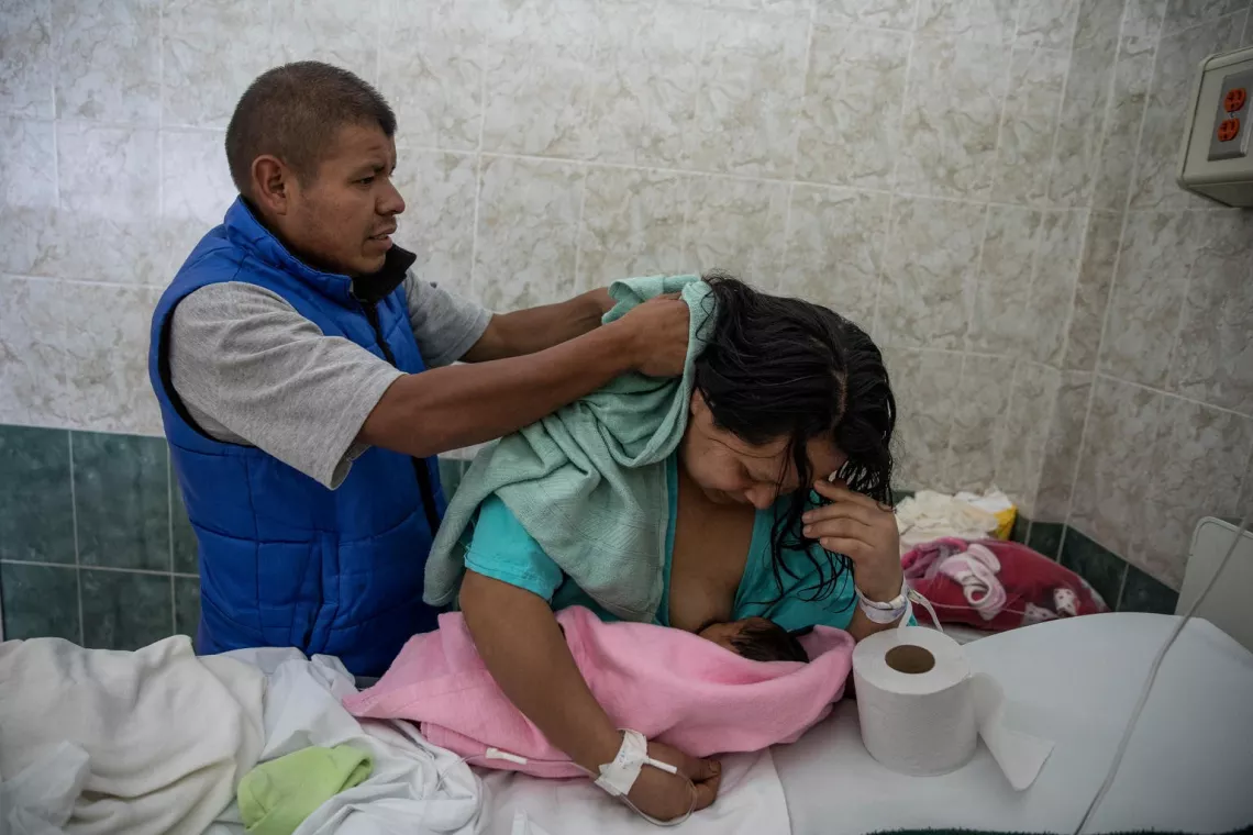 Man helps his breastfeeding wife dry her hair