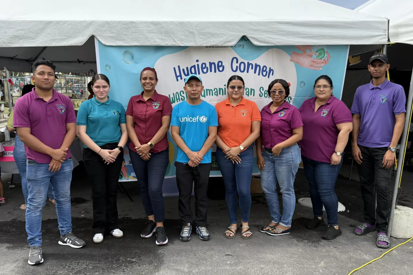 Shona Jonas Migrant Support Manager at Blossom Inc with UNICEF WASH Officer Gaulbert Sutherland and other officials at the Mobile Hygiene Corner
