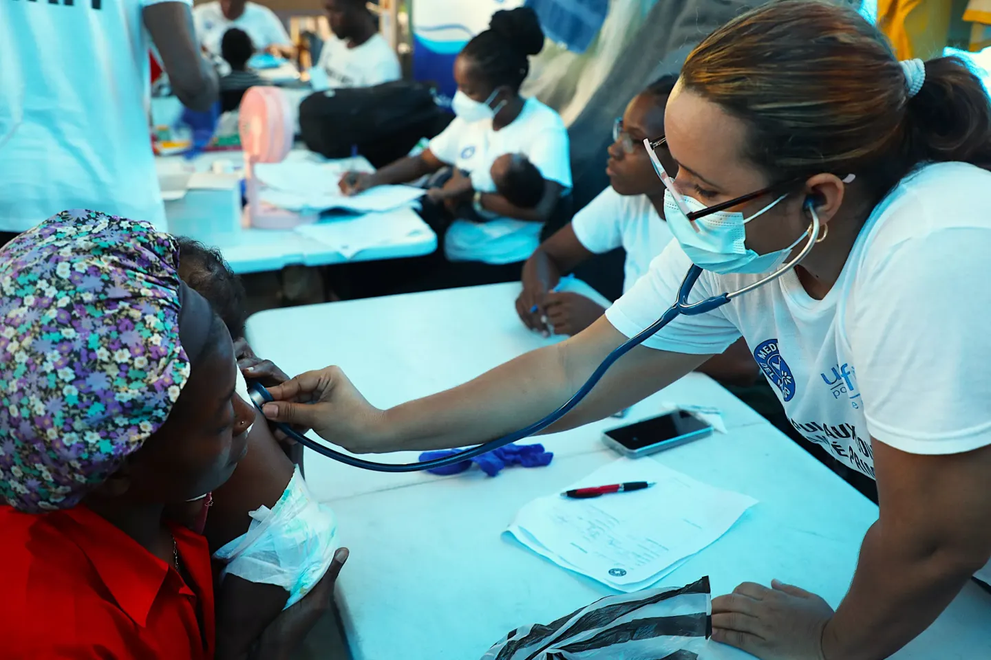 Une infirmi&egrave;re de M&eacute;decins du Monde en train de consulter des familles sur le site