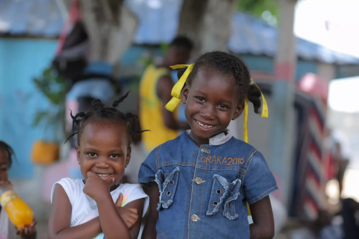 Two smiling young girls pose for the camera at the Anacaona site in Léogâne.