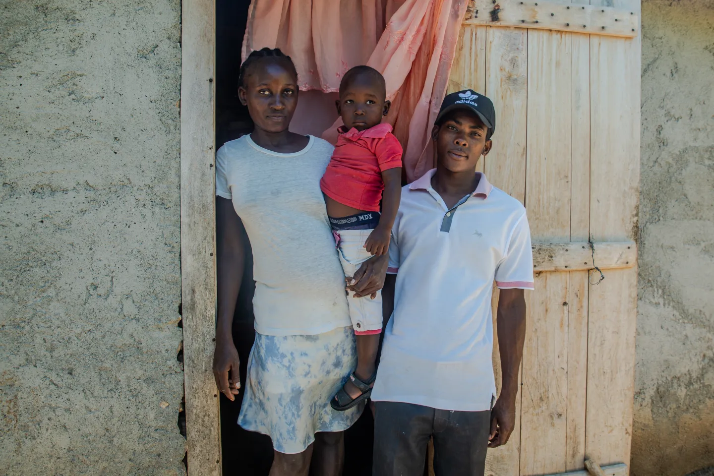  Davidson and his family stand in front of their house in Gros-Morne, Haiti.