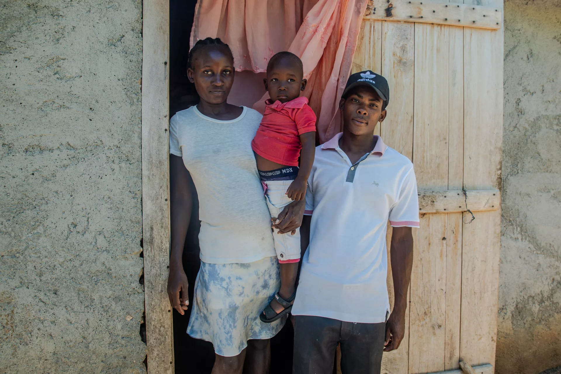 Davidson and his family stand in front of their house in Gros-Morne, Haiti.