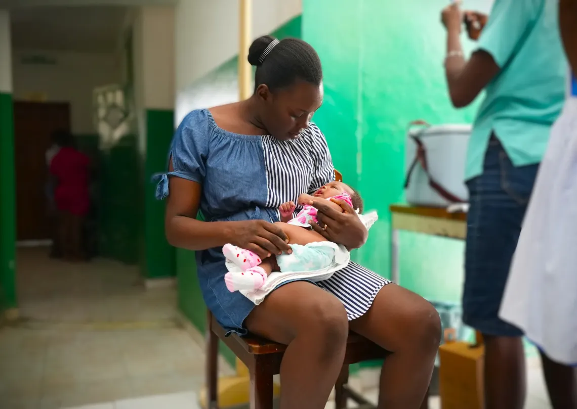  Cefaneffe holds her daughter Anne close after her vaccination.