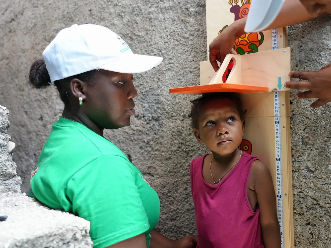 A health agent measuring a child
