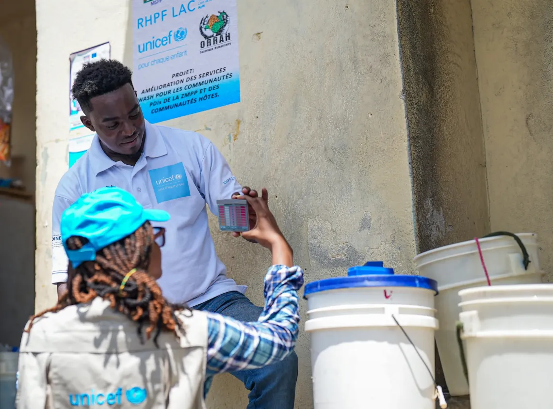 In the field, a worker from a UNICEF partner checks water quality by measuring residual chlorine and pH with a colourimetric comparator.