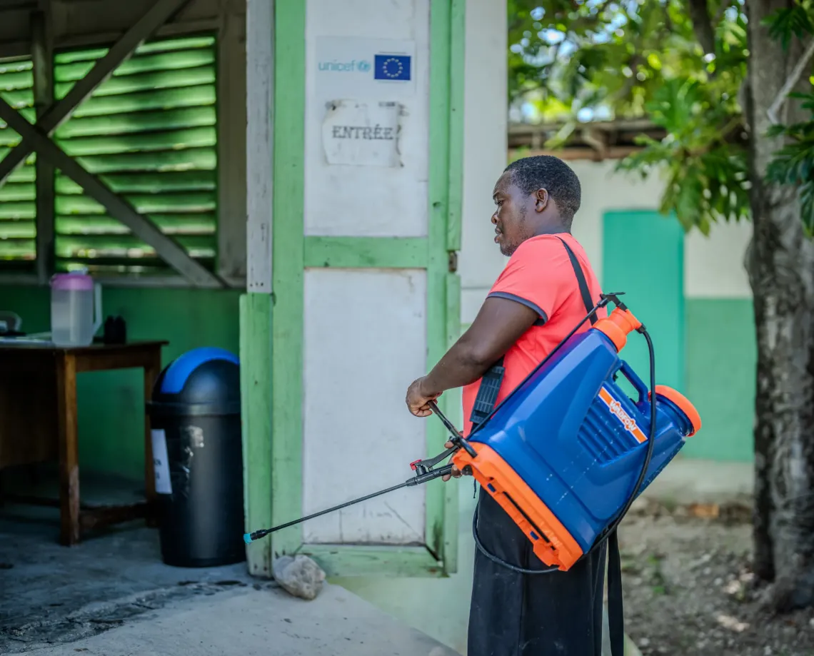 Tam , un agent de sant&eacute; communautaire form&eacute; &agrave; la pr&eacute;vention du chol&eacute;ra proc&egrave;de &agrave; la d&eacute;contamination du centre de sant&eacute; de Belle-Anse.