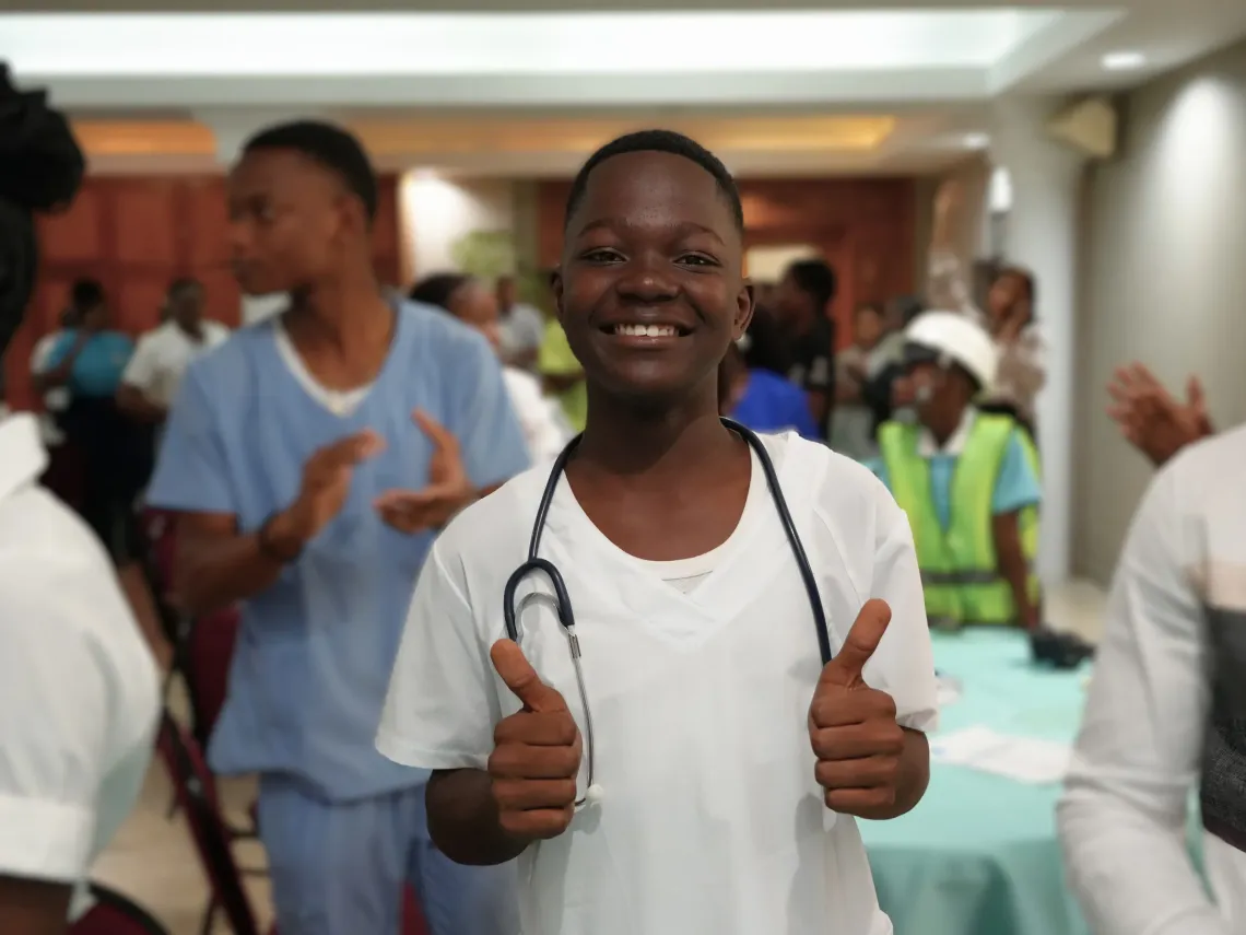 A young boy wearing a nursing scrub