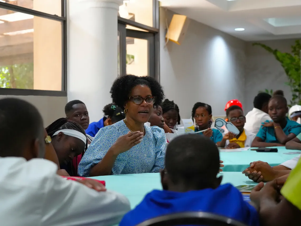 A lady talks to a group of children