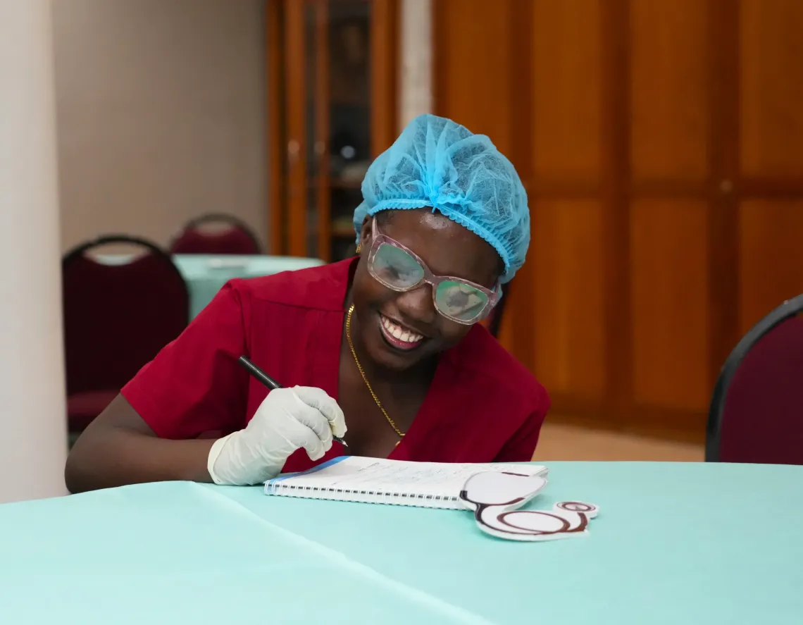 A young girl smiles while writing a note