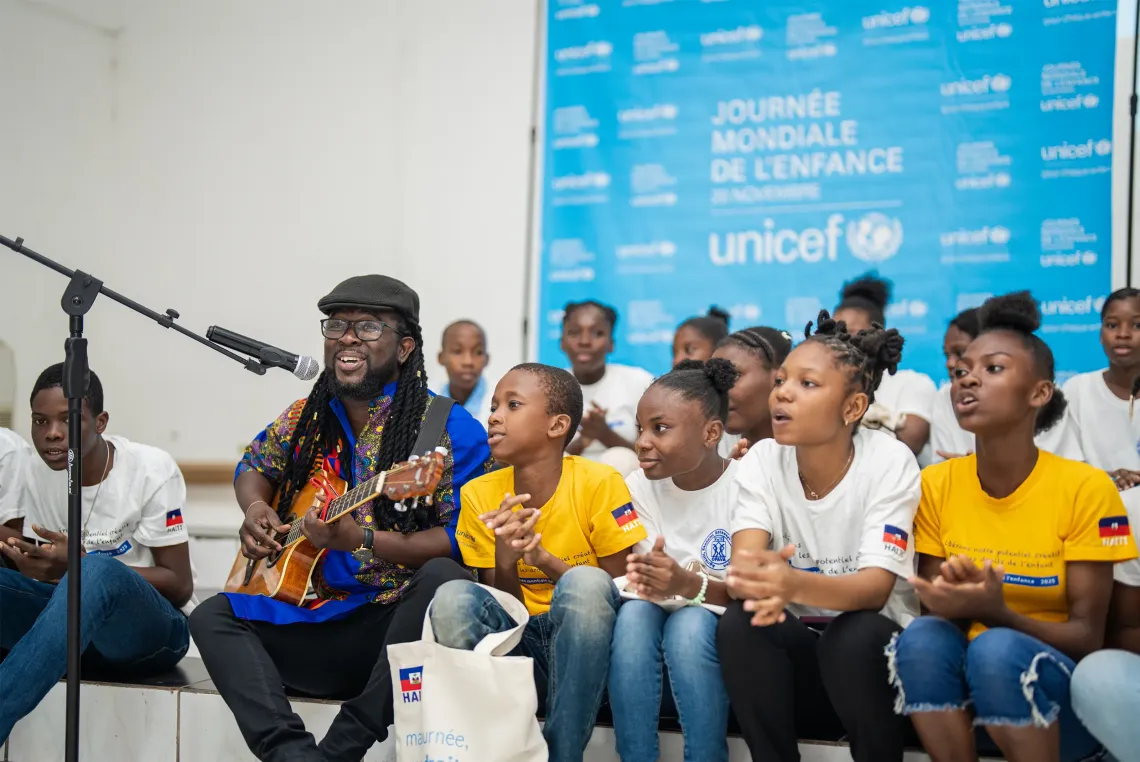 A young man singing with children