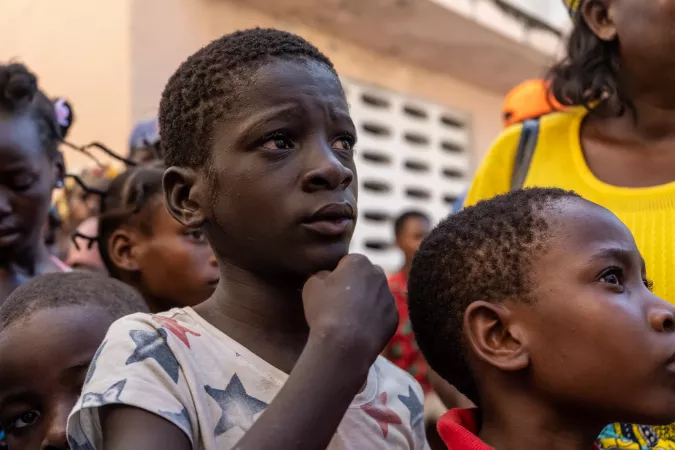  A child displaced by the crisis waits to receive aid with their family.