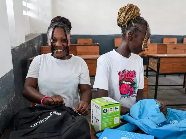 Sofia, 16 years old, smiling after receiving her backpack to go to school.
