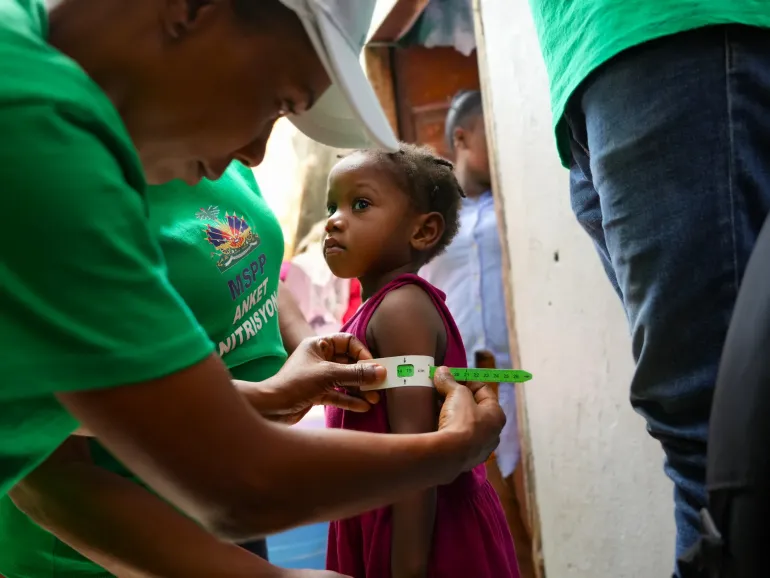 Une petite fille se fait mesurer le p&eacute;rim&egrave;tre brachial dans le cadre de l&rsquo;Enqu&ecirc;te nutritionnelle SMART 2026 en Ha&iuml;ti, afin de d&eacute;pister d&rsquo;&eacute;ventuels signes de malnutrition.